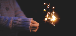 Person holding a sparkler in the darkness