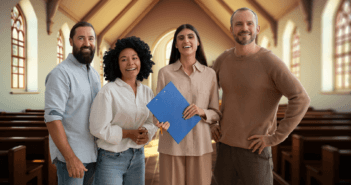 Smiling church staff posing together in a church sanctuary