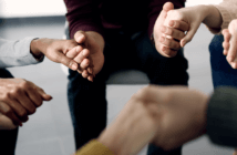 Group holding hands in prayer