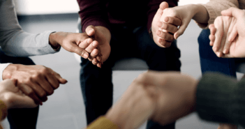 Group holding hands in prayer