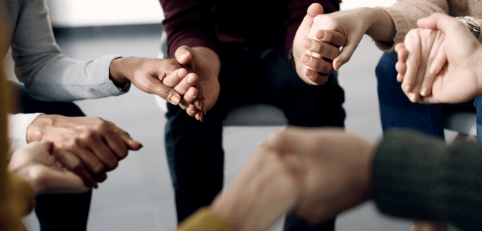 Group holding hands in prayer